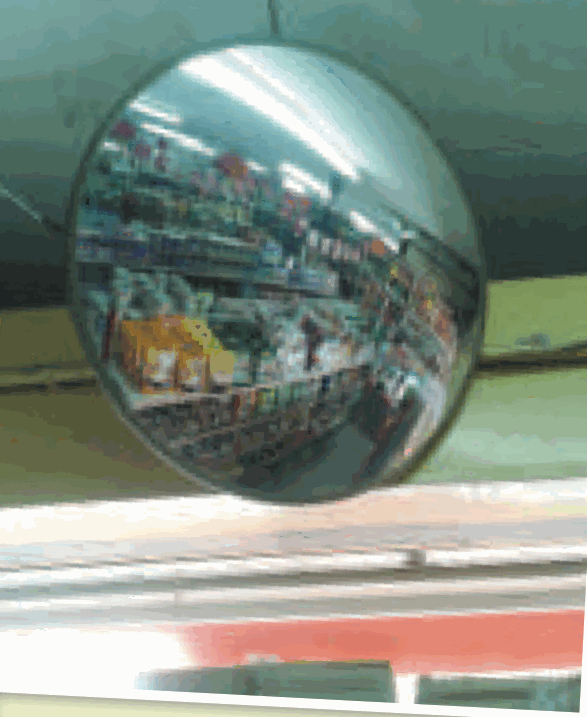 A round dome mirror on a supermarket ceiling